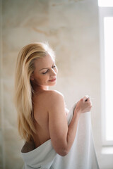 Naklejka premium Beautiful woman wearing a bathrobe. Young happy woman enjoing in hotelroom.