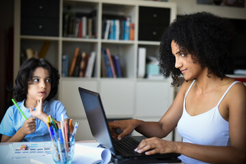 metis woman working home with her son doing his homework