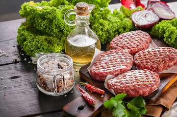Close up raw burger cutlets. Food still life. Organic meat, red onion, parsley leaves, spices, chili peppers. Copy space. Top view