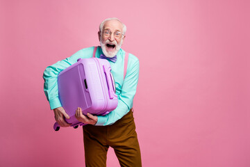 Cheerful crazy old man win summer air flight plane weekend hold trolley scream wear teal turquoise shirt brown pants trousers isolated over pink pastel color background