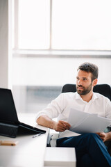 Fototapeta premium Businessman working on a project in the office. Young businessman working in office.