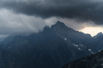 Dark cloudy sunset with light catching a little piece of rock. Dangerous conditions in Tatra...