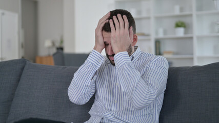Frustrated Young Man with Headache at Home 