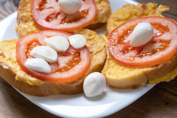 Toasts with fresh tomato and mozzarella for breakfast in the morning. Vegetarian meal