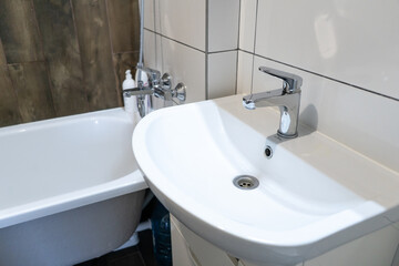 Modern white and wooden interior of bathroom with tup and sink. Hygiene and health