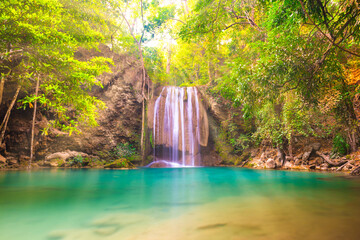 Tropical landscape with beautiful waterfall, emerald lake and green tree in wild jungle sunny forest. Erawan National park, Kanchanaburi, Thailand