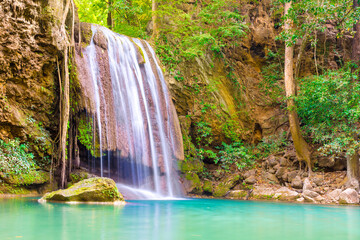 Fototapeta na wymiar Tropical landscape with beautiful waterfall, wild rainforest with green foliage and flowing water. Erawan National park, Kanchanaburi, Thailand