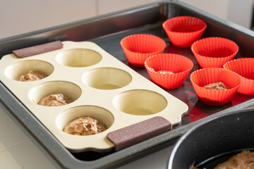Round shaped boxes with raw chocolate and vanilla cupcakes on white table in the kitchen