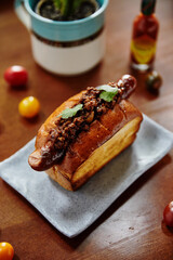 plate with baked bread and sausage on wooden table, close view hot dog