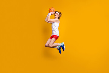 Fototapeta na wymiar Full length body size view of his he nice funky cheerful cheery glad successful guy jumping throwing ball goal leisure isolated over bright vivid shine vibrant yellow color background