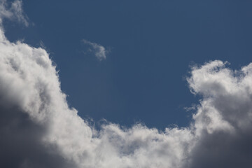 Dense white clouds on a background of blue sky