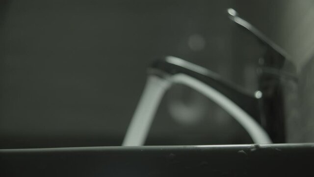 Water pours from the tap, high pressure, defocus