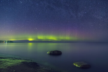 Aurora borealis. Northern Lights over a lake. Ladoga lake. Leningrad region, Russia