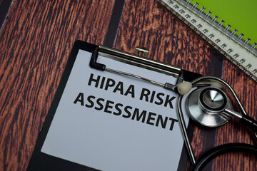 Hipaa Risk Assessment write on paperwork isolated on wooden table.
