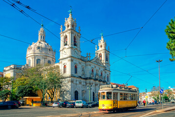 Estrela Basilica or the Royal Basilica is an ancient carmelite convent in Lisbon, Portugal. Vintage yellow tram on the old streets of Lisbon. Famous landmarks of Lisbon. - obrazy, fototapety, plakaty