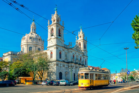 Estrela Basilica or the Royal Basilica is an ancient carmelite convent in Lisbon, Portugal. Vintage yellow tram on the old streets of Lisbon. Famous landmarks of Lisbon.