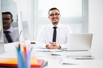 Happy arab businessman smiling while looking at camera in office