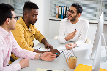 Multy-ethnic group of creative business people working with computer at office