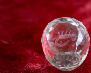 A glass egg with iridescent faces and inside the zodiac sign Scorpio.