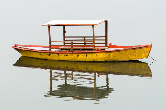 Isolated old small wooden boat surrounded by water 