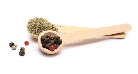 Colorful mixed pepper grains and milled powder with wooden spoon isolated on white background
