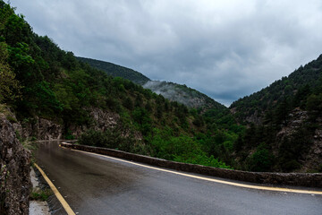Asphalt road through the mountains forest in rainy season