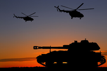 Fototapeta premium Silhouettes of army tank and helicopters at sunset outdoors. Military machinery