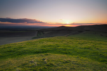 Fototapeta na wymiar Sunset from the top of Knap Hill looking across the Vale of Pewsey and Salisbury Plain, North Wessex Downs, Wiltshire, UK