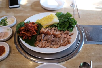 Gongju/Republic of Korea-January 18, 2020 : Picture taken at noodle shop 'Goganae Kalguksu'. There is a bossam. Bossam is boiled pork eaten with a saltysauce and wrapped in greens