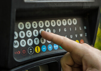  Finger pressing a pin code on a number pad.