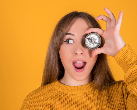woman with a compass covering her eye, surprised face