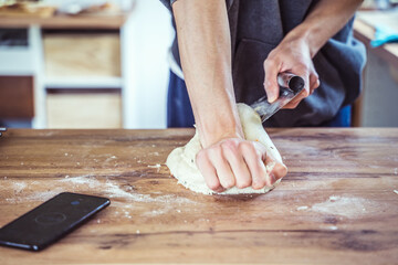 Young male home baker preparing artisan sourdough bread dough.