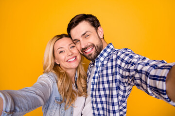 Closeup photo of pretty blond overjoyed lady handsome brunet guy couple spend quarantine together making selfies bloggers wear casual shirts isolated yellow color background