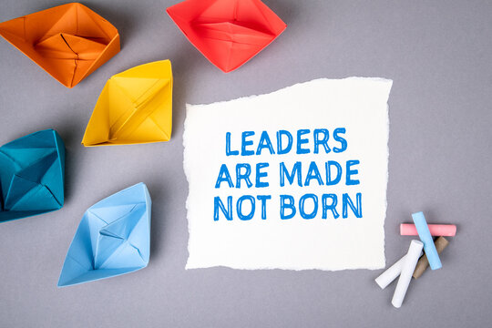 LEADERS ARE MADE NOT BORN. Text On Note Sheet, Paper Boats