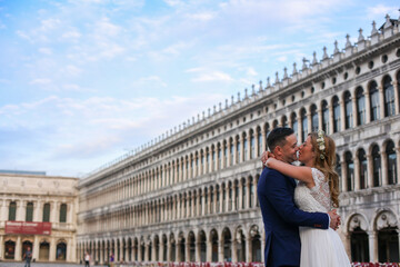 Obraz premium Young wedding couple posing in venice square