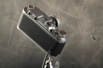 A vintage lamp made by me from an old rangefinger film camera Zorki relased on 1955 on a gray cement background.