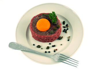 Steak tartare served on a plate on a white background