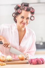 Young female with an unhappy face expression cuts onion with a knife