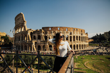 Woman at Colosseum, Rome, Italy. Happy girl near famous ancient Coliseum historic tourist attraction in Roma. Roman Empire. Architecture building landmark. Great Colosseum.