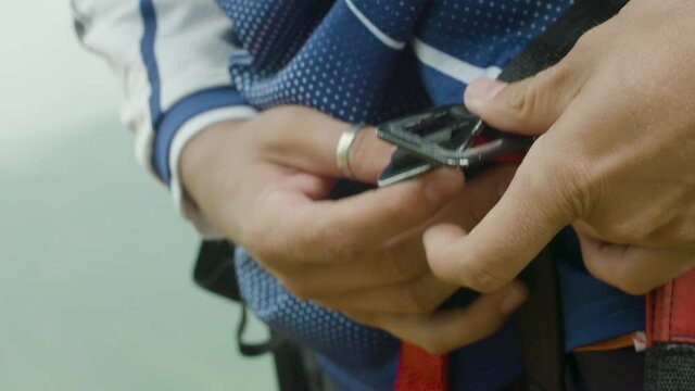Close up of putting on the harness for paragliding in the mountains. Slow motion