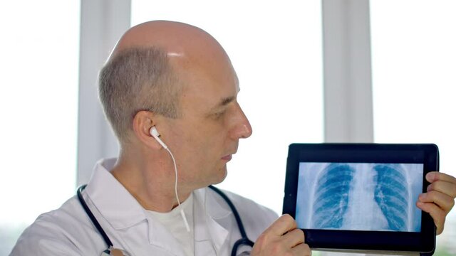 Practitioner doctor showing lung scan on tablet pc while online consultation with patient. Pulmonologist showing pneumonia xray picture while remote reception