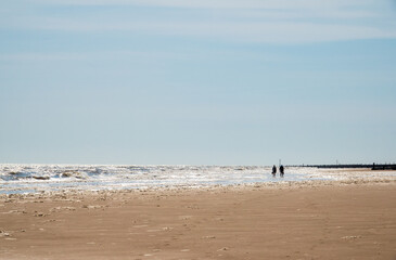 Silhouette of couple walking on beach.