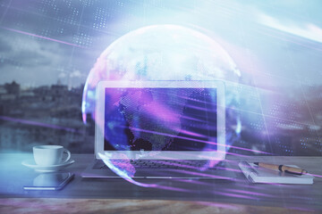 Computer on desktop in office with technology theme hologram. Multi exposure. Tech concept.