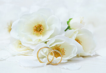 Obraz na płótnie Canvas Wedding rings on background of roses
