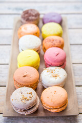 Cake macaroons of different colors. Sweet french dessert on a light wooden background. Colorful macaroons.
