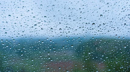 raindrops on the glass close-up. Background, texture. Bad weather. Blue tint.