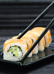 Philadelphia Sushi with chopsticks on black dish