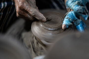 male potter is making a vase from clay, selective focus.
