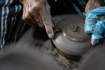 male potter is making a vase from clay, selective focus.