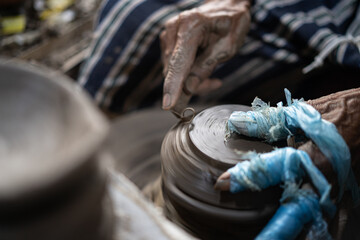 male potter is making a vase from clay, selective focus.
